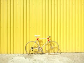 a bike parked in front of a yellow wall
