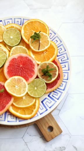 a plate of citrus fruit on a wooden cutting board