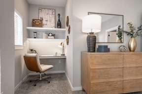 A room with a chair, a desk, and a mirror.