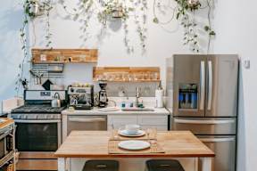 A kitchen with a wooden table and stainless steel appliances.