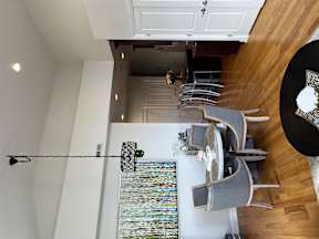 an aerial view of a living room with a dining room table and a staircase