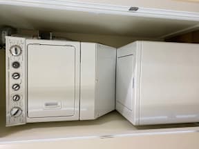 A white oven and microwave are installed in a kitchen cabinet.