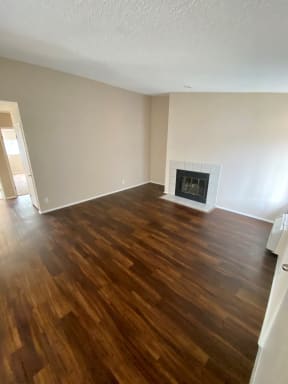 Beautiful wood plank style flooring and fire place in living room of Grande Vista Apartments.