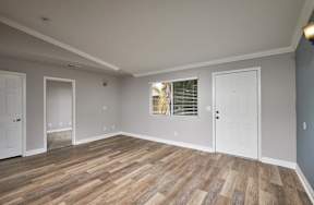 A room with wooden flooring and white walls.