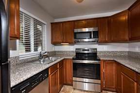 A kitchen with wooden cabinets and granite countertops.
