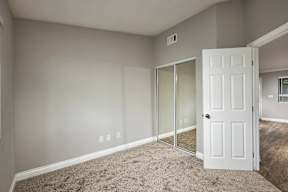 A room with a white door and carpeted floor.
