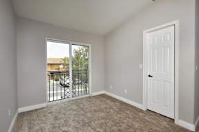 A room with a sliding glass door leading to a balcony.