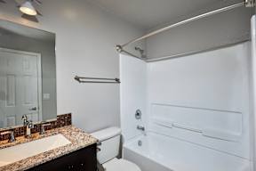 A white bathroom with a sink, toilet, and bathtub.