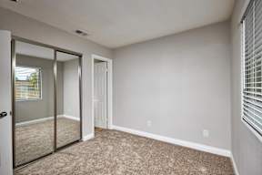 A room with a carpeted floor and a sliding glass door.