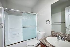 A bathroom with a toilet, sink, and shower.