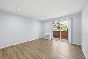 A room with a sliding door leading to a balcony.