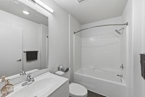 A white bathroom with a toilet, sink, and bathtub.