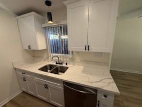 A kitchen with white cabinets and a marble countertop.