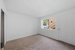 Empty room with a carpeted floor and white walls.