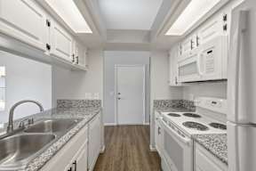 A kitchen with white appliances and cabinets.