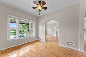 A room with a ceiling fan and wooden floors.