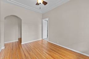 A room with a wooden floor and a ceiling fan.