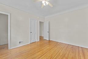 A room with wooden floors and a ceiling fan.
