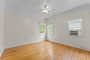 A room with wooden floors and a ceiling fan.