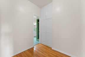 A room with white walls and wooden floors with a white door.