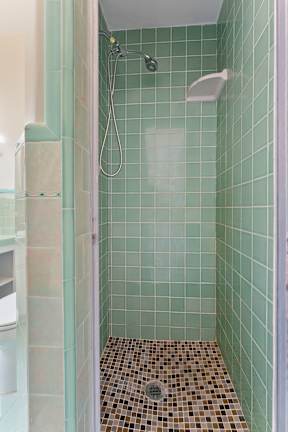 A shower with a tiled floor and a shower head.