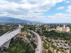 A highway with cars driving on it and a mountain in the background.