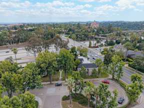 A view of a roundabout with cars and trees from a high angle.