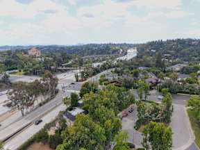 A view of a highway with cars driving on it and a bridge in the background.