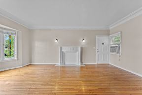 A room with a fireplace and wood flooring.