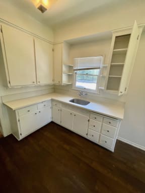 Corner view of kitchen cabinets and hardwood floors at Orange Grove Apartments in Pasadena, CA.