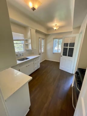 Kitchen with breakfast nook and hardwood floors at Orange Grove Apartments in Pasadena, CA.