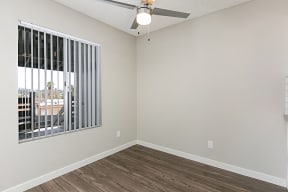 Dining area with ceiling fan and verticle blinds at Solara Apartments.