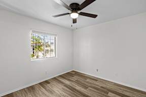 A room with a ceiling fan and a window.