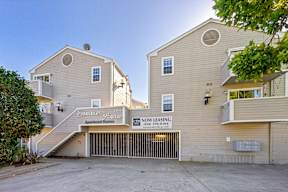 A two-story apartment building with a sign that says "The Sunrise Homeowners.".