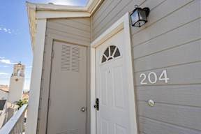 A white door with a window above it and a number 204 on the wall.