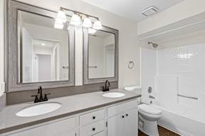 A bathroom with a sink, mirror, and toilet.