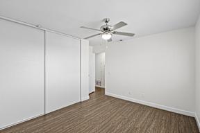 A room with a ceiling fan and sliding doors.