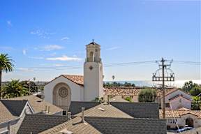 A church with a clock tower is seen from a high vantage point.