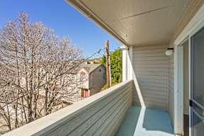 A balcony with a view of a house and trees.