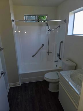 A white bathroom with a toilet, sink, and shower.