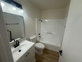 A white bathroom with a toilet, sink, and shower.