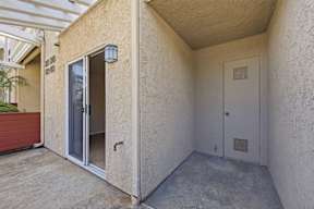 A white door is on the right side of a room with a concrete floor.