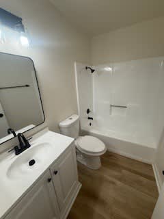 A white bathroom with a toilet, sink, and bathtub.
