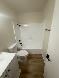 A white toilet and sink in a small bathroom.