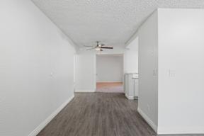 A room with a ceiling fan and wooden flooring.