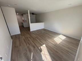 A room with wooden flooring and white walls.
