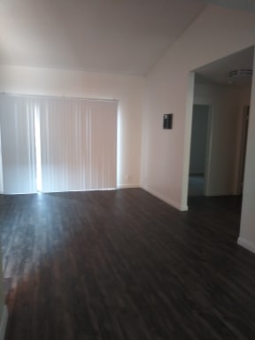 Vertical blinds in living room and wood style vinyl floors at La Costa Seashore Apartments in Carlsbad, CA.