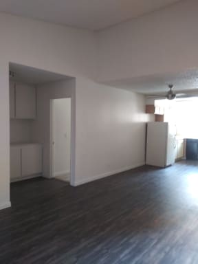 Living room view of kitchen and hallway to bedrooms with built-in cabinets at La Costa Seashore Apartments.