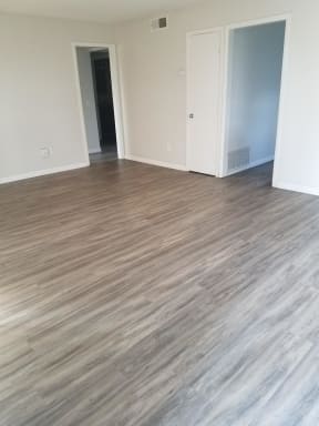 Living room with hardwood flooring at Tulip Street Apartments in Escondido, California.