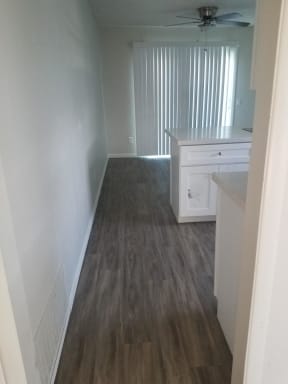 Kitchen and dining area with ceiling fan and sliding glass doors to porch at Tulip Street Apartments in Escondido, California.